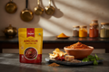 A bright, appetizing Indian kitchen or dining setup showcasing Zaykoo Instant Amchur (Dry Mango) Chutney Mix. In the foreground, a clean, modern Zaykoo packet with warm yellow and red packaging labeled “Zaykoo – Instant Amchur Chutney Mix.” Beside it, a small bowl of vibrant reddish-brown chutney with a smooth yet slightly textured surface, representing tangy dry mango flavor.

Around the bowl, arrange authentic ingredients — dried mango slices (amchur), red chillies, cumin seeds, jaggery, and coriander — t